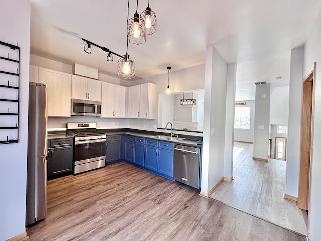 2278 Twilight Dr, Aurora, IL 60503 - kitchen featuring light wood-style flooring, hanging light fixtures, blue cabinets, a sink, and appliances with stainless steel finishes