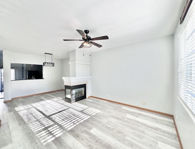 2278 Twilight Dr, Aurora, IL 60503 - unfurnished living room with ceiling fan, light wood-style flooring, baseboards, and a multi sided fireplace