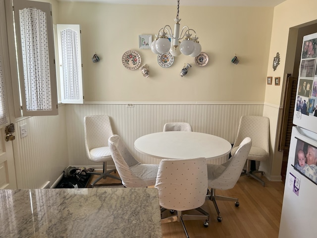 7924 Tripp Ave, Skokie, IL 60076 - dining area featuring a chandelier, a wainscoted wall, and wood finished floors