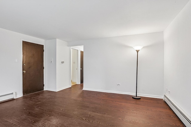spare room with a baseboard radiator, baseboards, and wood finished floors