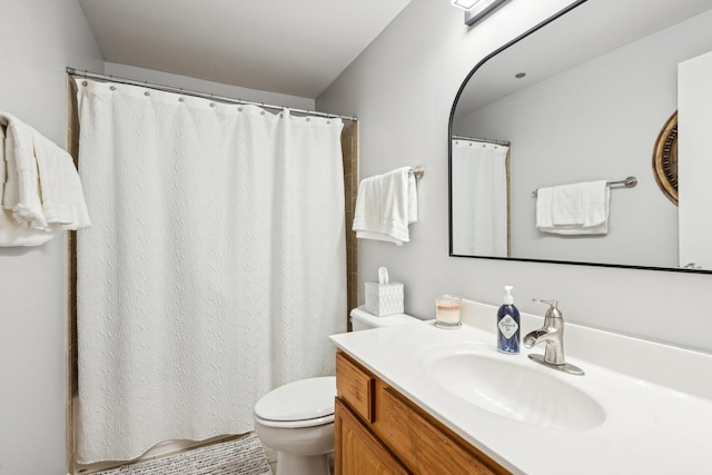 bathroom with curtained shower, vanity, and toilet
