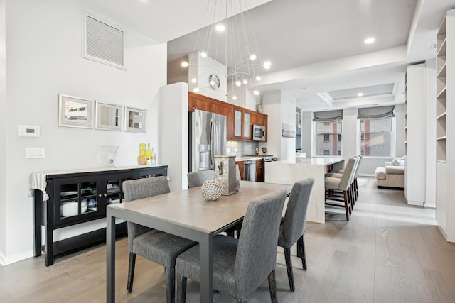 dining space featuring light wood-style floors, visible vents, baseboards, and recessed lighting
