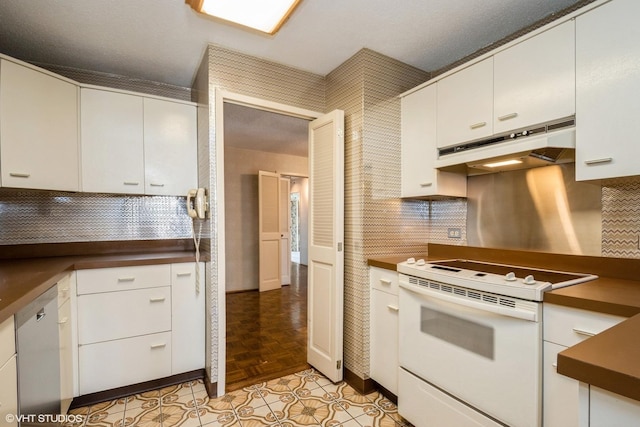 kitchen with white electric range, under cabinet range hood, dishwasher, dark countertops, and white cabinets