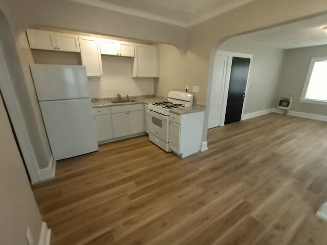 kitchen featuring a sink, crown molding, white appliances, and white cabinets