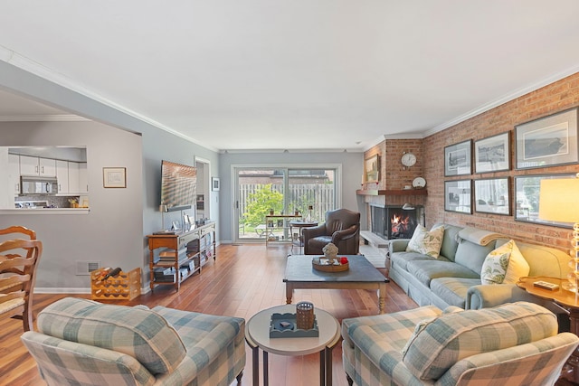 1805 Wildberry Dr Unit C, Glenview, IL 60025 - living area featuring hardwood / wood-style flooring, brick wall, a brick fireplace, crown molding, and baseboards