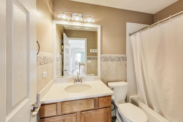 full bathroom featuring a wainscoted wall, vanity, tile walls, and toilet