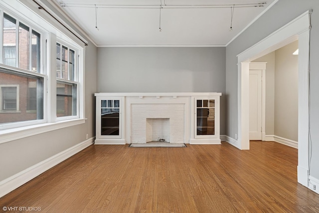 6104 S Kimbark Ave Unit 1, Chicago, IL 60637 - unfurnished living room featuring crown molding, wood finished floors, baseboards, and a brick fireplace