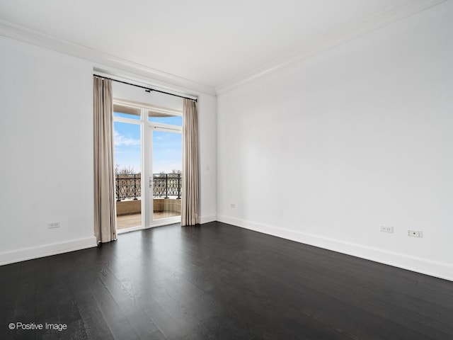 empty room featuring dark wood-type flooring, baseboards, and ornamental molding