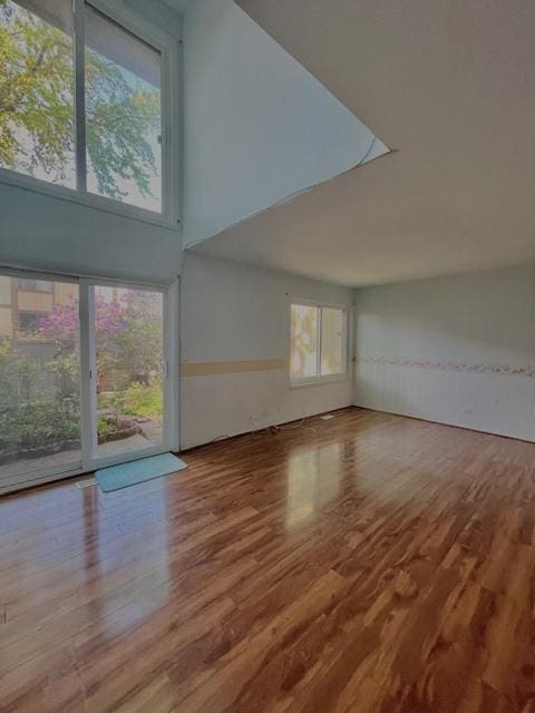 610 E Woodfield Trl, Roselle, IL 60172 - unfurnished living room with wood finished floors, a wainscoted wall, and a high ceiling