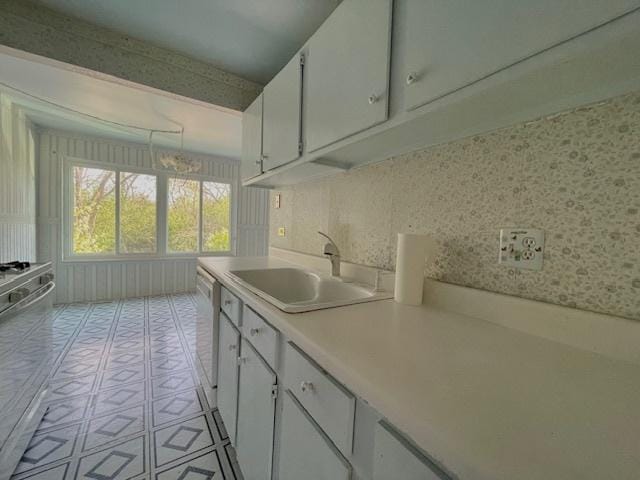 610 E Woodfield Trl, Roselle, IL 60172 - kitchen with a sink, light countertops, white cabinets, light tile patterned floors, and white dishwasher