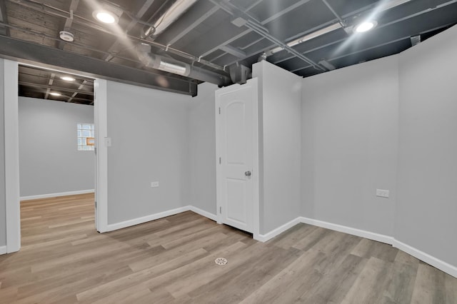 basement with baseboards and wood finished floors
