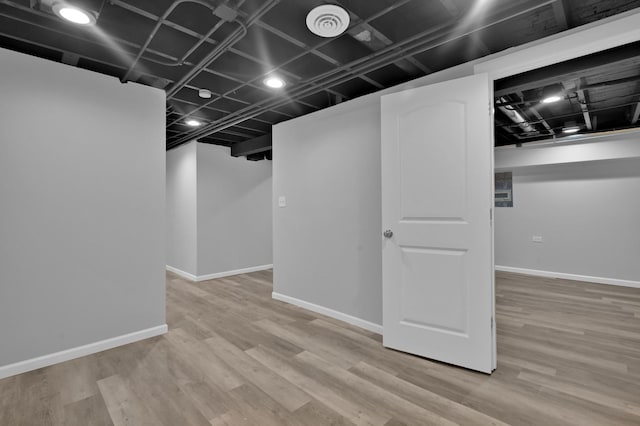 finished below grade area with baseboards and wood finished floors
