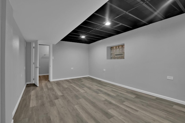 finished below grade area with baseboards and wood finished floors
