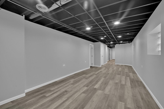 finished basement featuring baseboards and wood finished floors