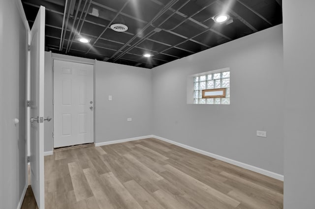 unfurnished room with baseboards and light wood-style floors