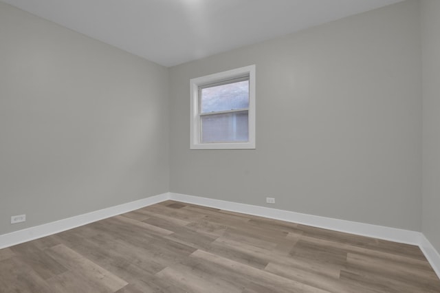 empty room featuring wood finished floors and baseboards