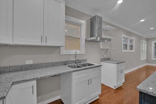 kitchen with open shelves, a sink, wall chimney exhaust hood, and white cabinets
