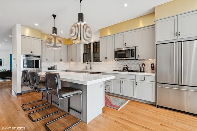 837 W 34th Pl, Chicago, IL 60608 - kitchen featuring stainless steel appliances, gray cabinets, decorative backsplash, light wood-style flooring, and recessed lighting
