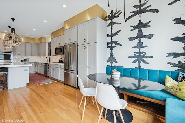 837 W 34th Pl, Chicago, IL 60608 - kitchen with appliances with stainless steel finishes, tasteful backsplash, light countertops, a sink, and gray cabinets