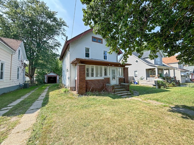 rear view of property featuring an outdoor structure, a detached garage, brick siding, driveway, and a yard