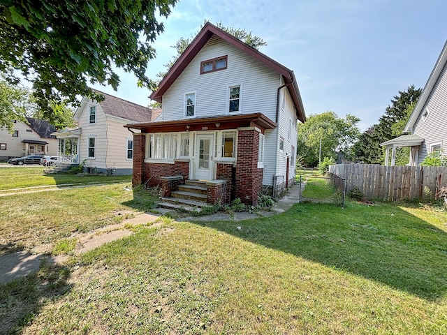 view of front of property featuring fence, a front lawn, and brick siding