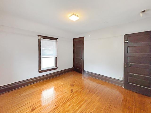 empty room featuring wood finished floors and baseboards
