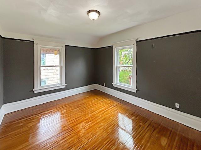 empty room with baseboards and wood finished floors