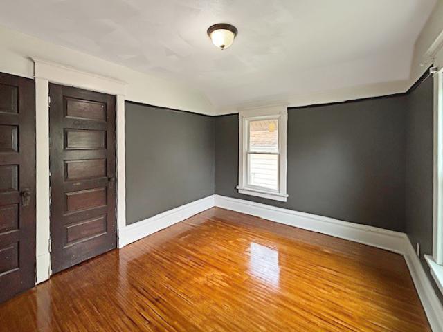 empty room with wood finished floors and baseboards