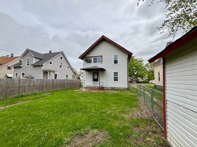 back of property featuring a lawn and a fenced backyard
