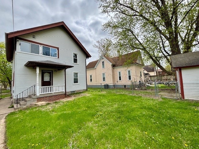 rear view of property featuring a yard and fence