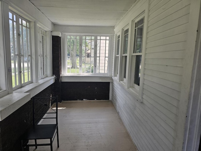 unfurnished sunroom with hardwood / wood-style floors and a healthy amount of sunlight