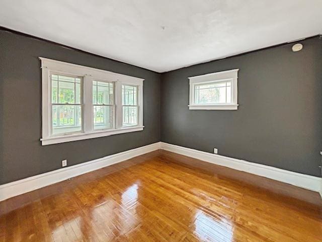 empty room with baseboards and wood finished floors