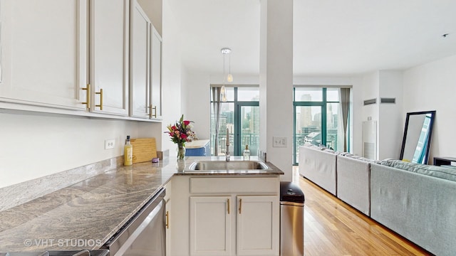 340 W Superior St Unit 1602, Chicago, IL 60654 - kitchen with dishwasher, open floor plan, a sink, light wood-style floors, and a peninsula