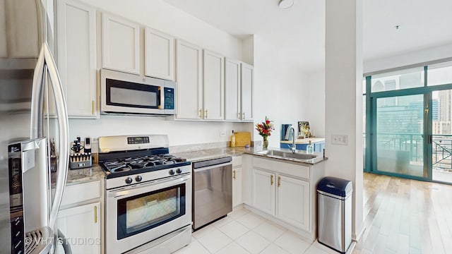 340 W Superior St Unit 1602, Chicago, IL 60654 - kitchen with stainless steel appliances, a sink, white cabinetry, and light stone counters