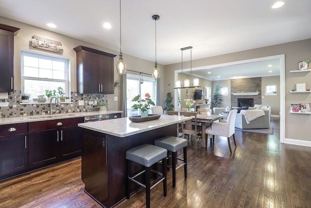 12911 Mayfair Dr, Lemont, IL 60439 - kitchen featuring a sink, decorative backsplash, a breakfast bar area, a kitchen island, and dark wood finished floors