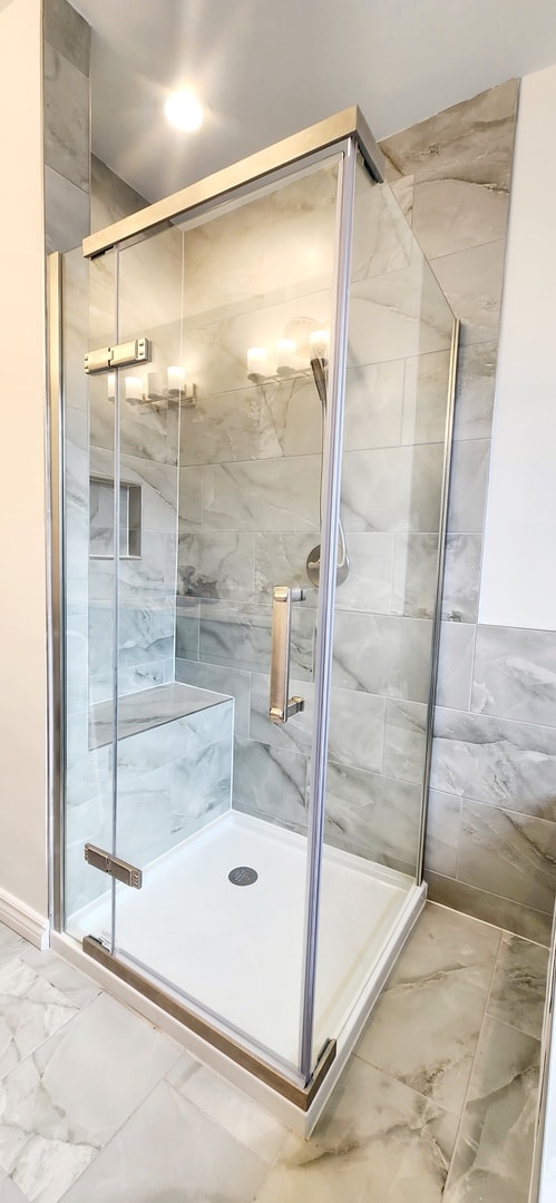 full bath featuring a shower stall and marble finish floor