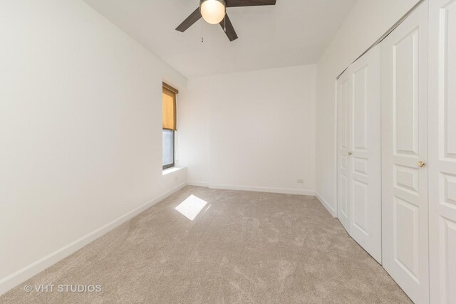 unfurnished bedroom featuring baseboards, light carpet, a closet, and ceiling fan