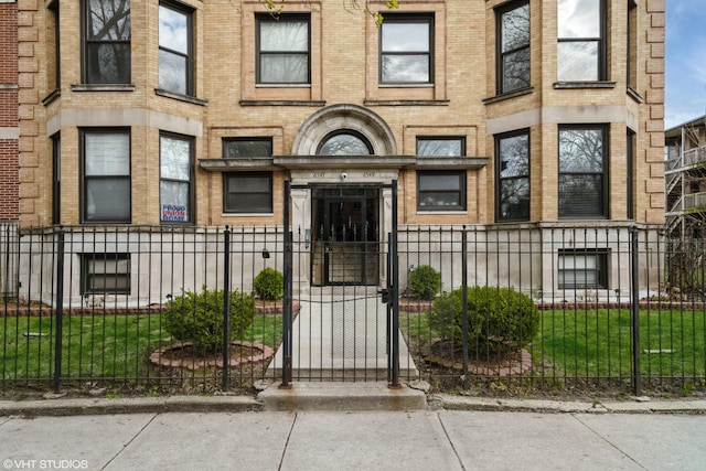 property entrance with brick siding, fence, and a gate