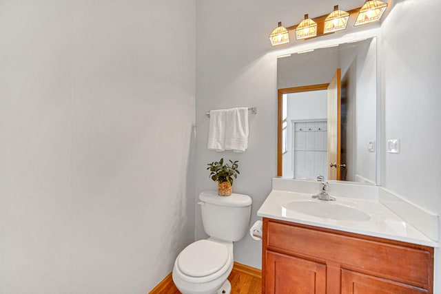 bathroom featuring toilet, vanity, and wood finished floors