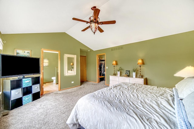 bedroom featuring carpet floors, vaulted ceiling, a walk in closet, a closet, and ensuite bathroom