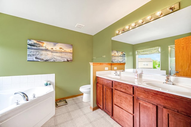 bathroom with tile patterned floors, double vanity, a garden tub, toilet, and baseboards
