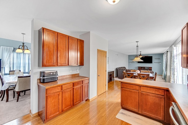 kitchen with light wood finished floors, pendant lighting, brown cabinetry, open floor plan, and a peninsula