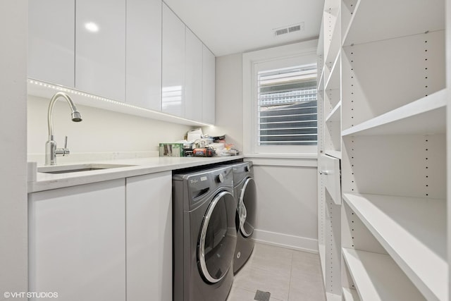 216 S Green St Unit 1N, Chicago, IL 60607 - washroom with washer and clothes dryer, light tile patterned flooring, baseboards, and cabinet space