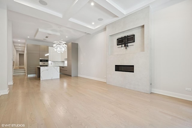 216 S Green St Unit 1N, Chicago, IL 60607 - unfurnished living room with light wood-style floors, coffered ceiling, baseboards, beamed ceiling, and a tile fireplace