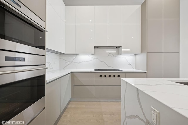 216 S Green St Unit 1N, Chicago, IL 60607 - kitchen with modern cabinets, light wood-style floors, light stone countertops, and stainless steel double oven