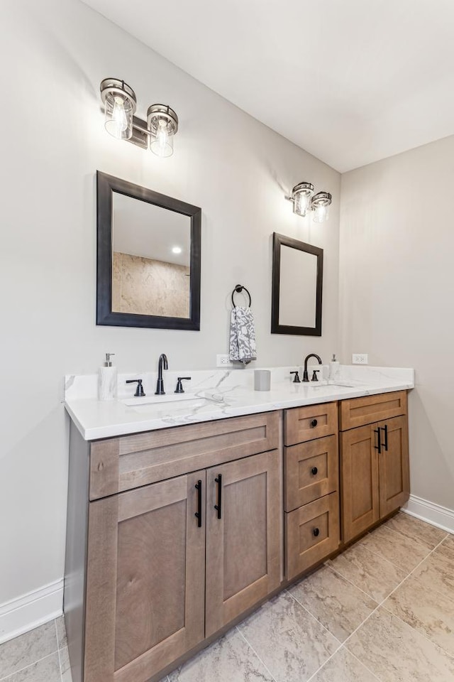 full bathroom with double vanity, baseboards, and a sink
