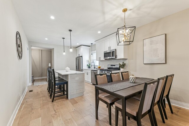 dining area featuring baseboards, light wood-style flooring, and recessed lighting