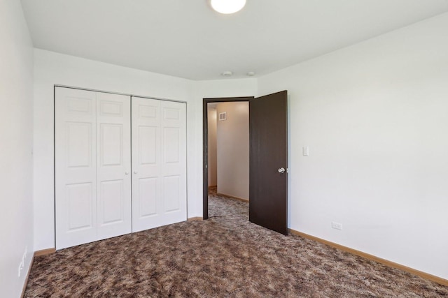 unfurnished bedroom featuring carpet, a closet, and baseboards