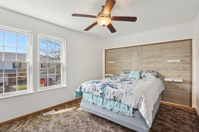 carpeted bedroom featuring baseboards and ceiling fan