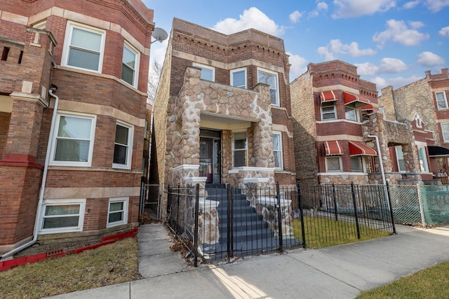 4843 W Gladys Ave, Chicago, IL 60644 - exterior space featuring stone siding, a fenced front yard, and a gate